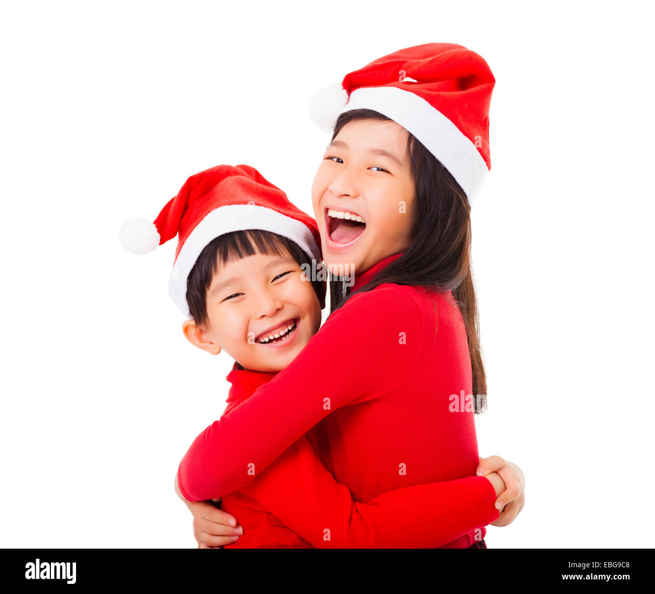 Due piccolo felice ragazze con cappello di Natale e dando un altro abbraccio Foto Stock