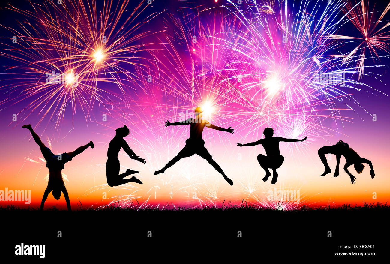 Felice giovani saltando su per la collina con fuochi d'artificio sfondo Foto Stock
