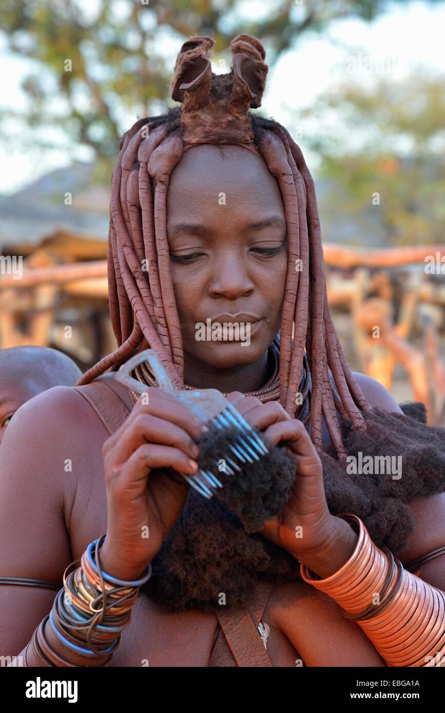 Donna Himba pettinare i capelli, Omuramba, Kaokoland, Kunene, Namibia Foto Stock