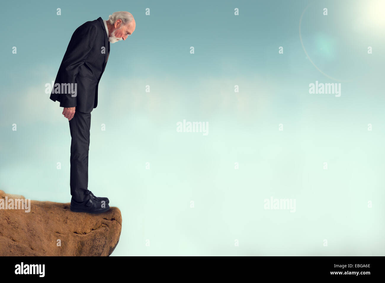 Senior uomo guardando in giù da una scogliera Foto Stock