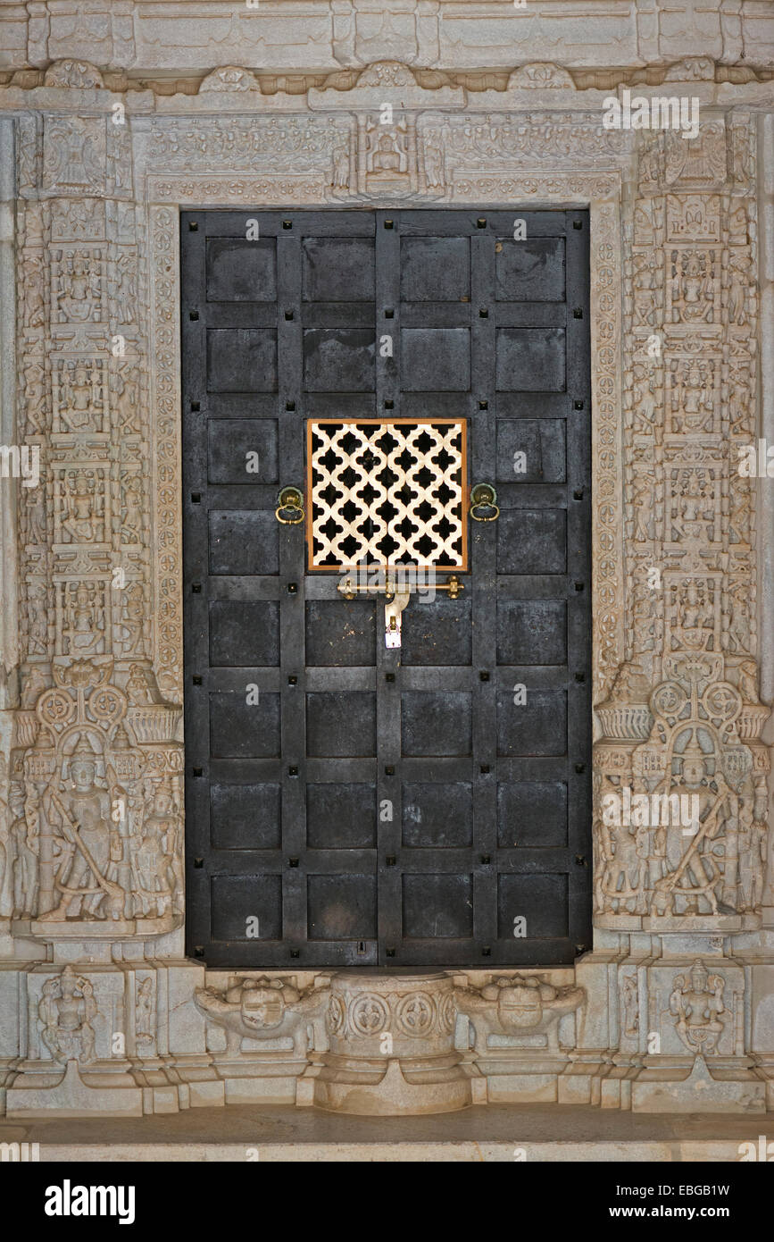 Porta in ferro incorniciato da colonne ornati, tempio in marmo, tempio della religione Jain, Adinatha Tempio Ranakpur, Rajasthan, India Foto Stock