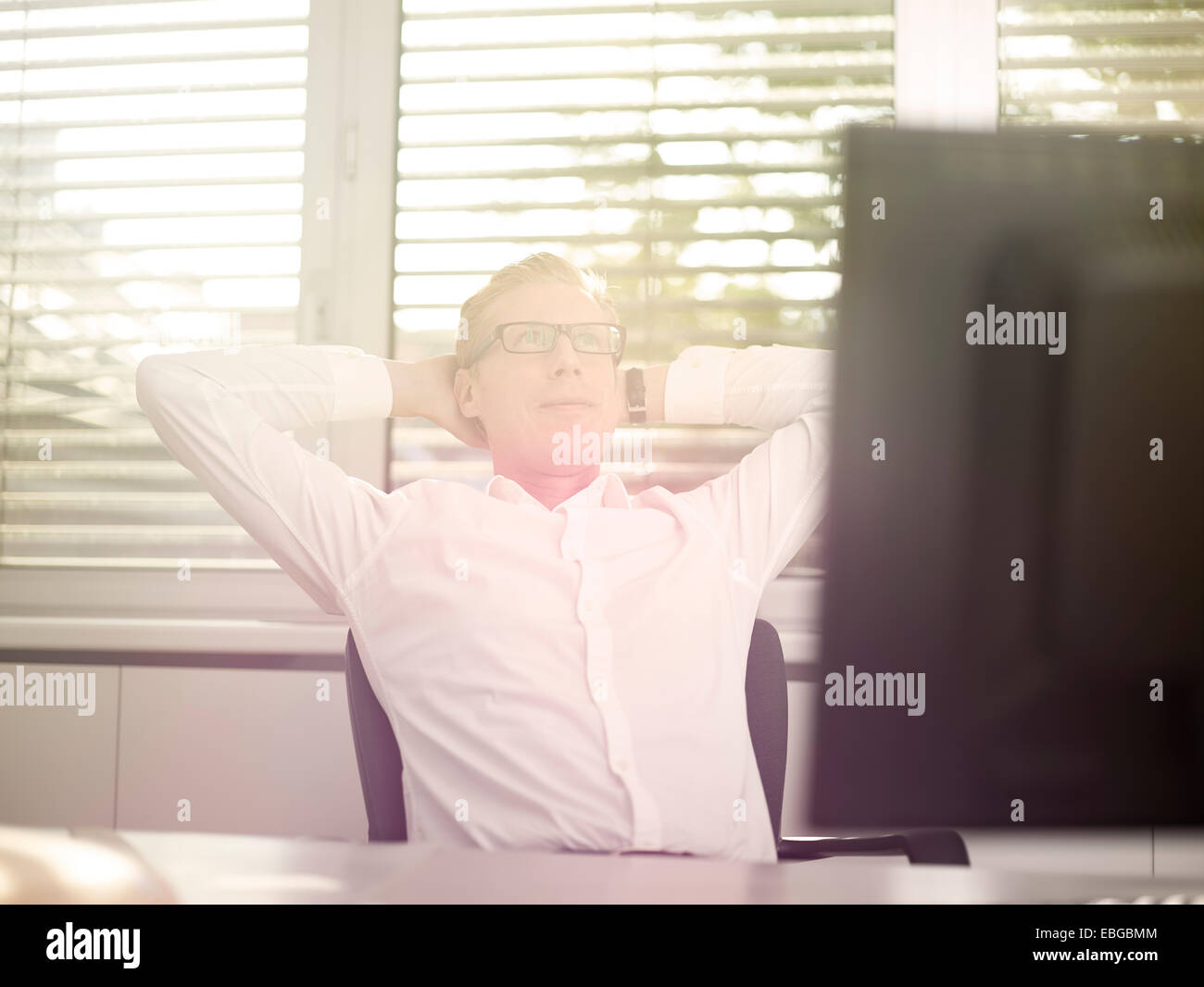 Uomo seduto davanti al suo computer in un ufficio, nel pensiero, Innsbruck, in Tirolo, Austria Foto Stock