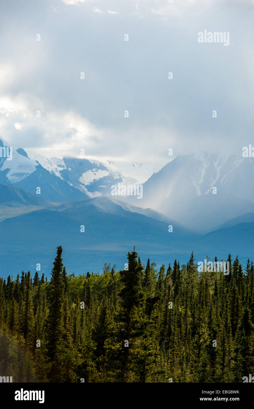 Alaska Range montagne essendo eclipse con pesante copertura nuvolosa Foto Stock