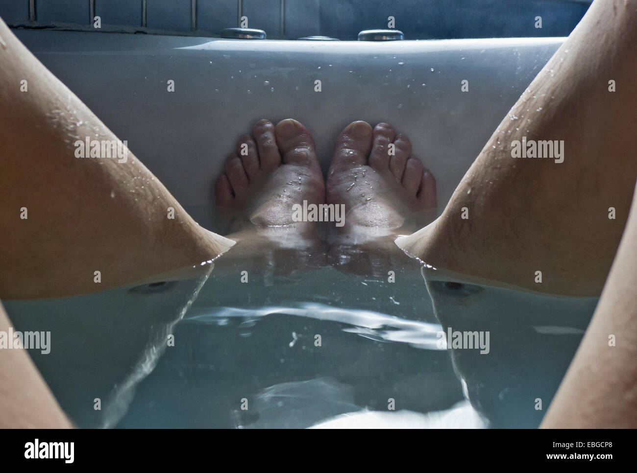 Un uomo di piedi nella vasca da bagno. Foto Stock