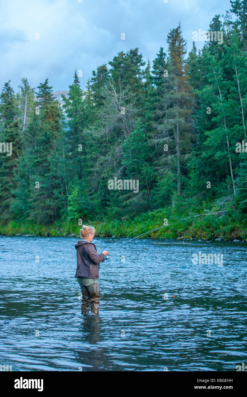La donna la pesca nel fiume russo vicino alla penisola di Kenai, Alaska Foto Stock