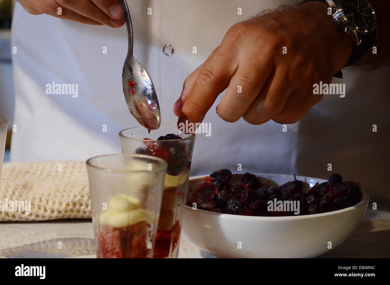 Chef preparando le mani con gelato alla vaniglia con frutti rossi Foto Stock