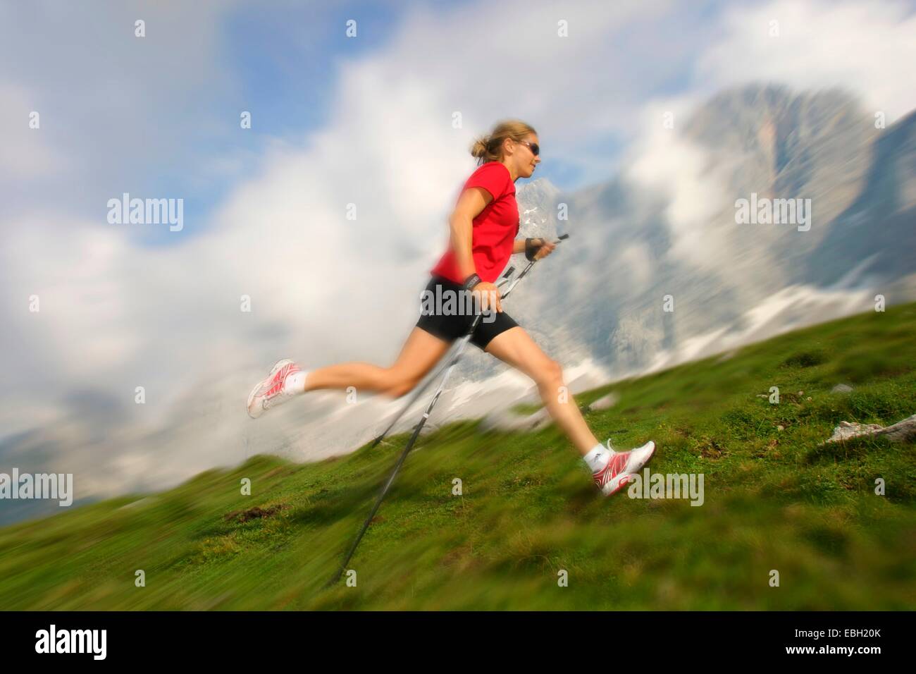 Nordic walking - giovane donna in montagna Foto Stock