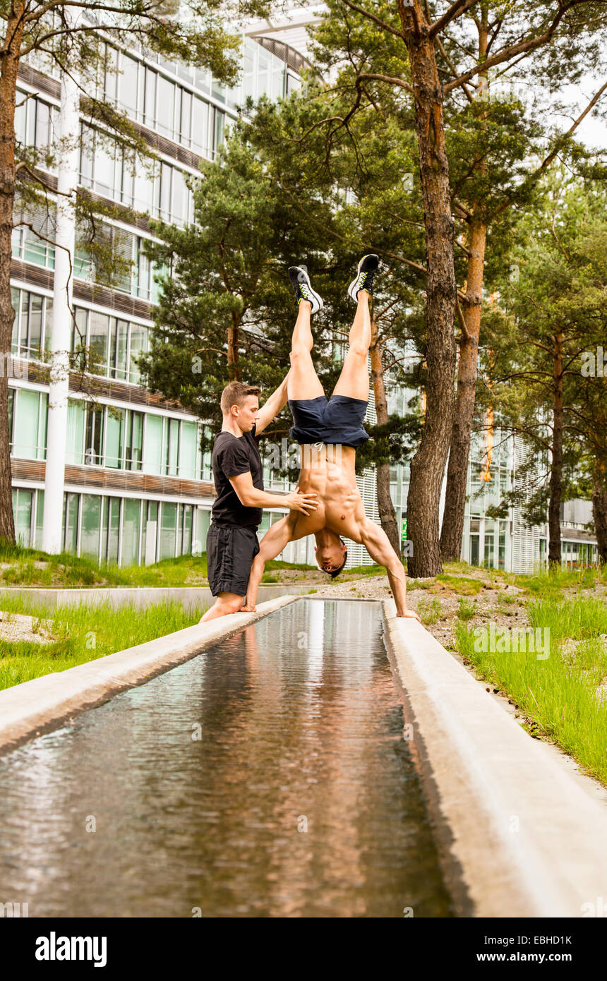Personal trainer facendo outdoor training in luogo urbano, Monaco di Baviera, Germania Foto Stock