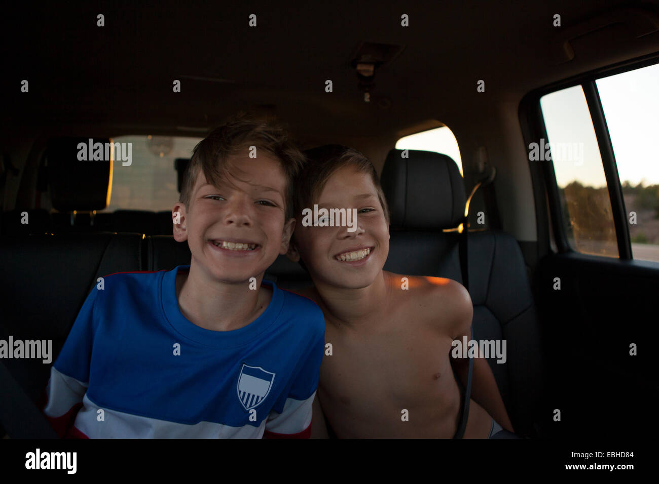 Ritratto di fratelli sorridente in auto sedile posteriore Foto Stock