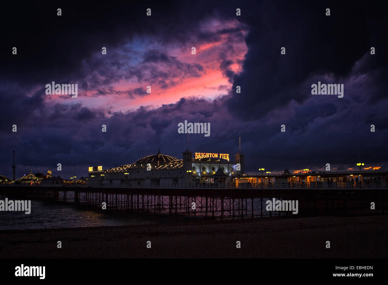 Nuvole di tempesta e il tramonto sul molo di Brighton Foto Stock