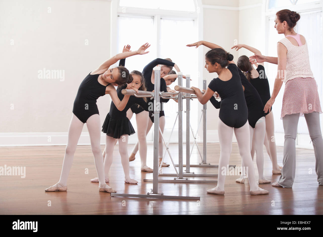 Insegnante di danza insegnamento gruppo di ragazze posizione di balletto a barre Foto Stock