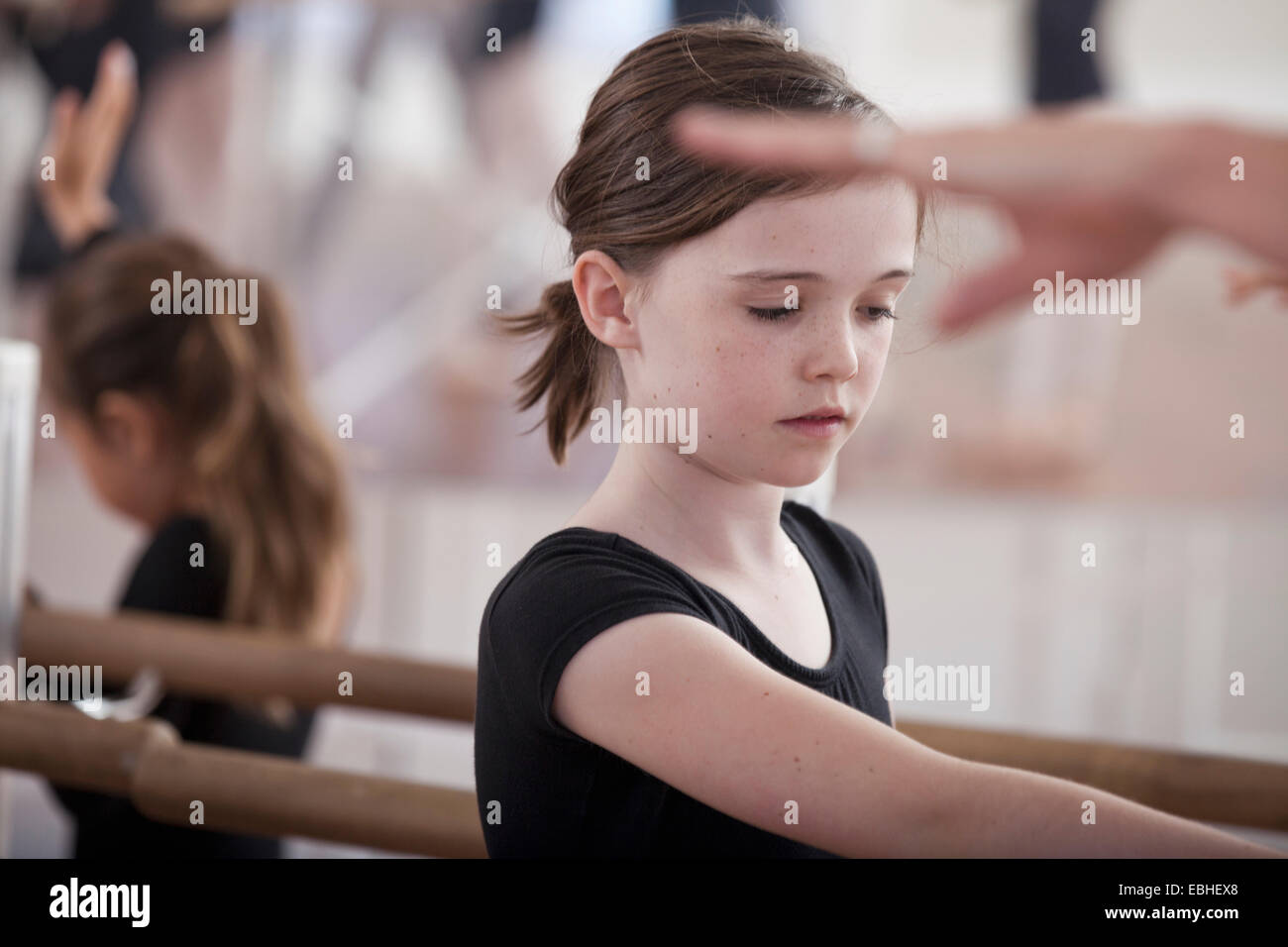 Scuola di danza ragazze praticanti posizione di balletto a barre Foto Stock