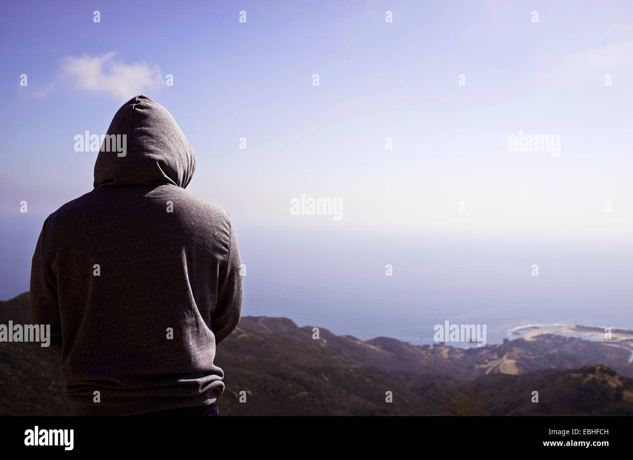 Vista posteriore di uomo maturo in felpa con cappuccio in parte anteriore del litorale Foto Stock