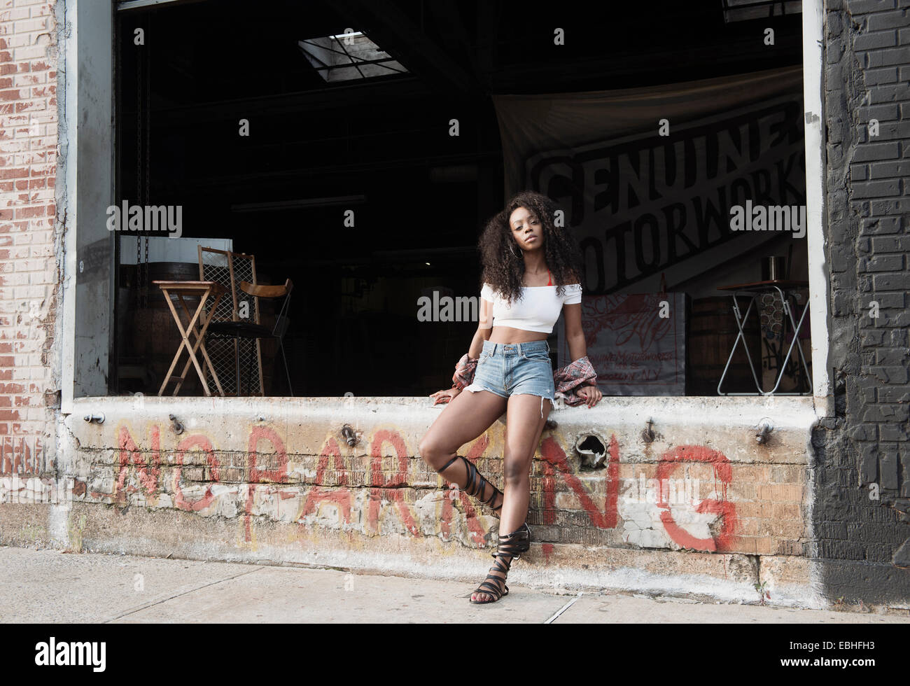 Giovane donna seduta sulla parete dicendo no parcheggio Foto Stock