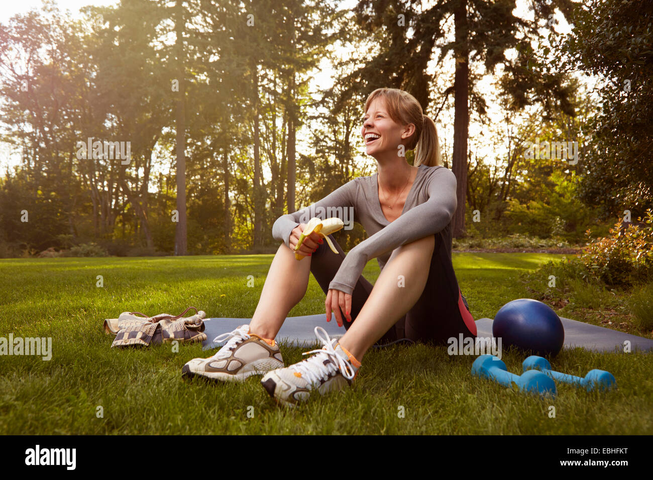 Metà donna adulta seduto in posizione di parcheggio facendo esercizio break Foto Stock