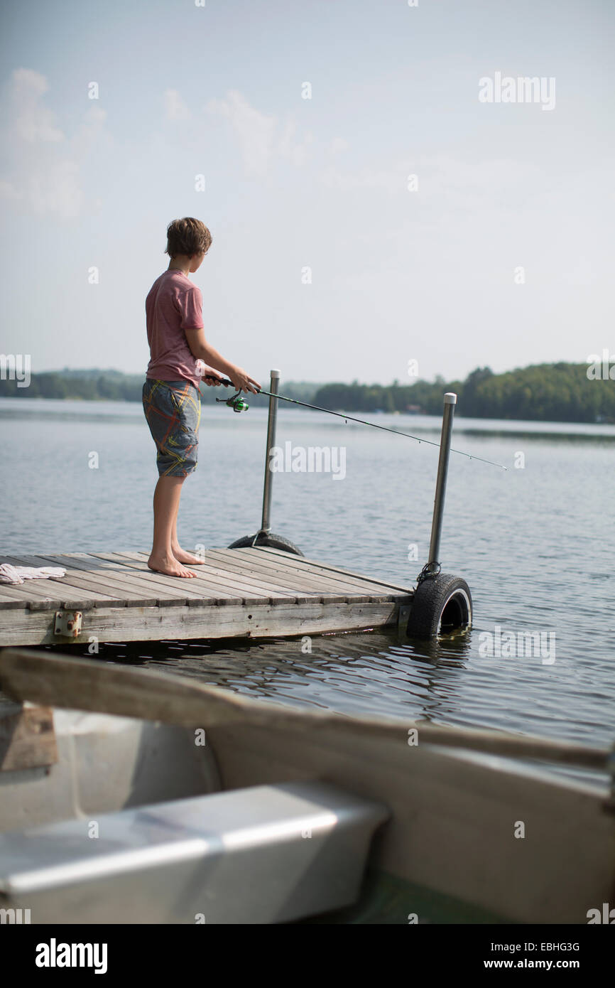 Ragazzo adolescente di pesca sul molo, Lago Superior, Gwinn, Michigan, Stati Uniti d'America Foto Stock