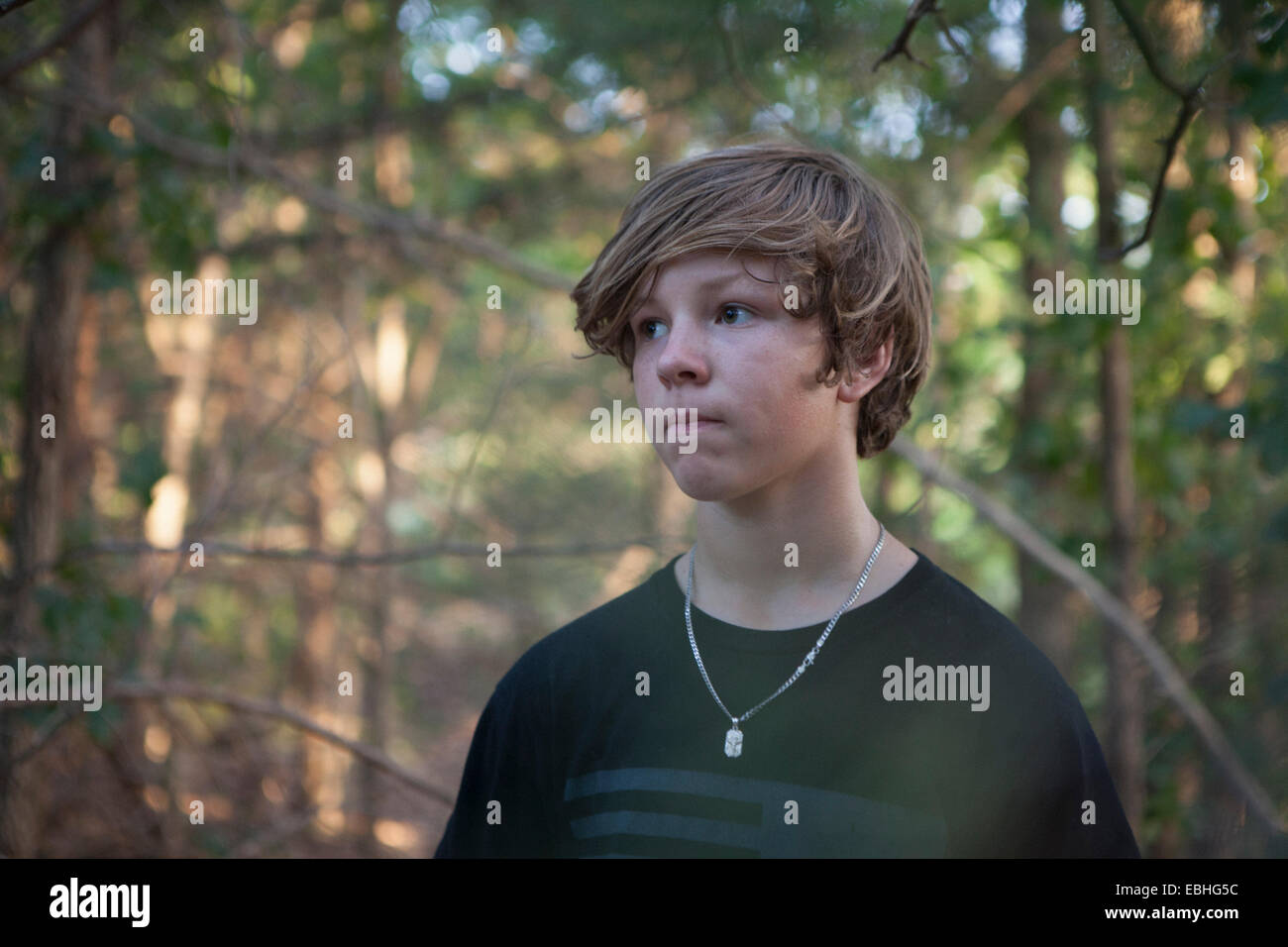 Ritratto di ragazzo adolescente nella foresta guardando lateralmente, Wichita Mountains National Wildlife Refuge, Indiahoma, Oklahoma, Stati Uniti d'America Foto Stock