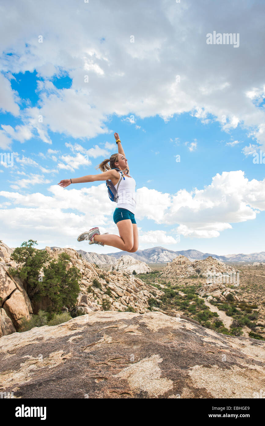 Donna salti di gioia sulla montagna, Joshua Tree National Park, California, US Foto Stock