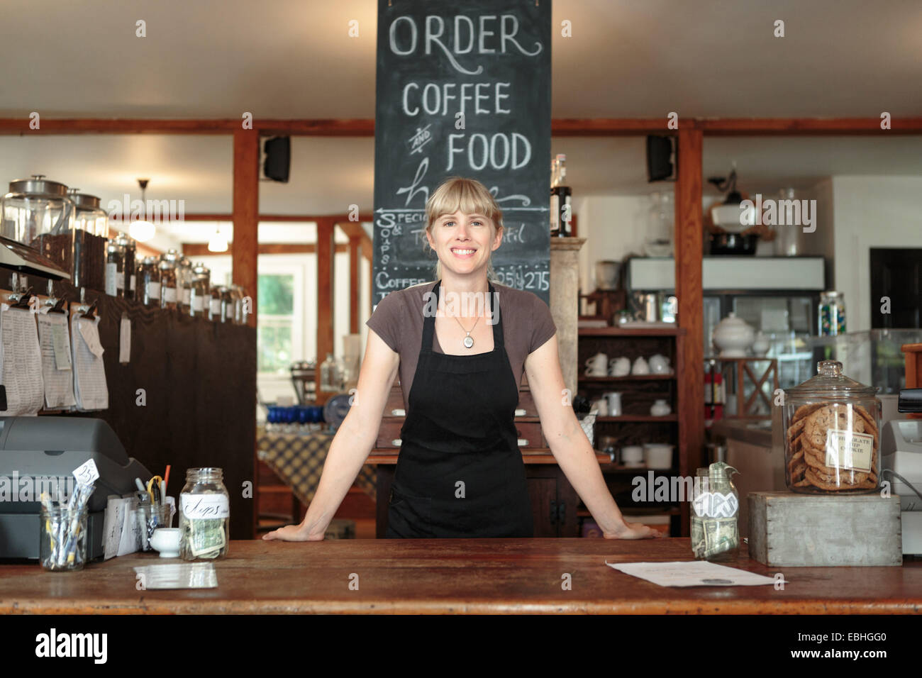 Ritratto di donna shop assistant in paese store cafe Foto Stock