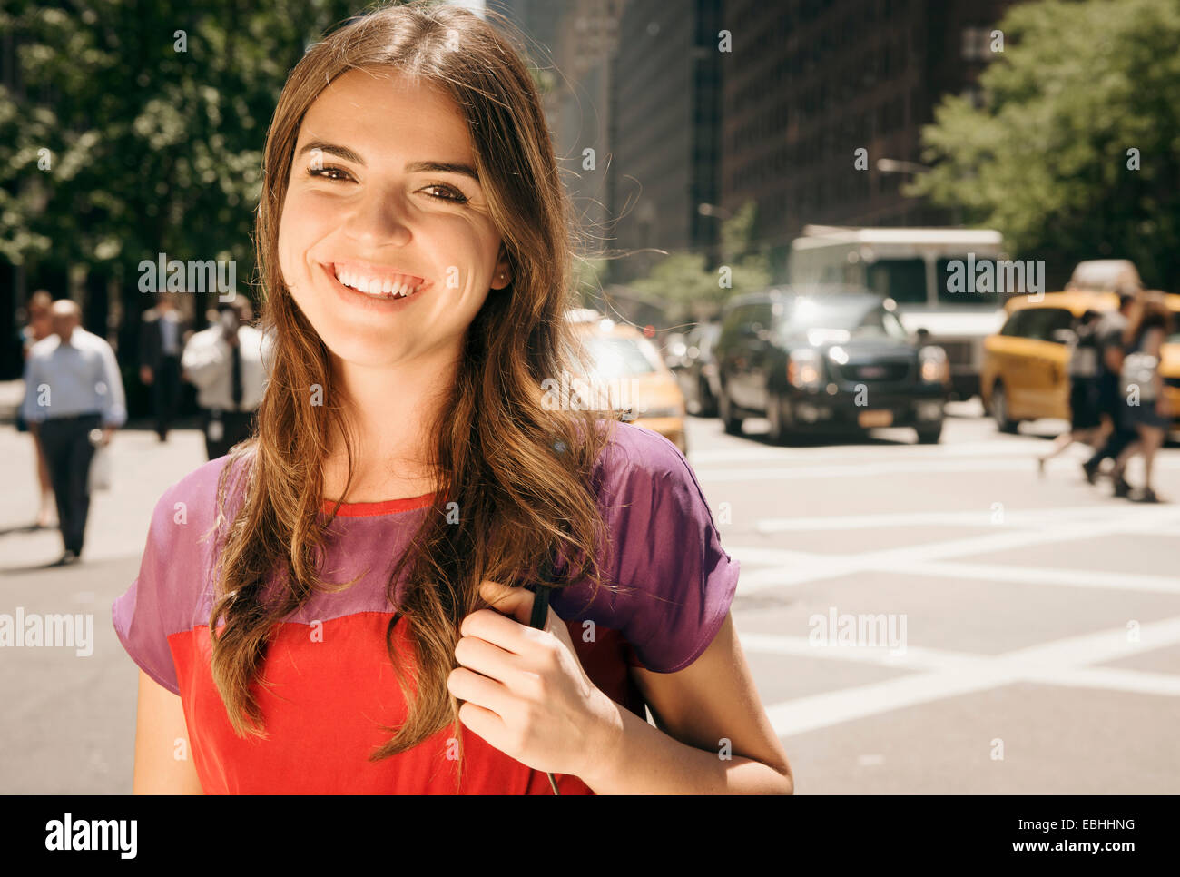 Giovane donna con capelli lunghi marrone in streetscene Foto Stock