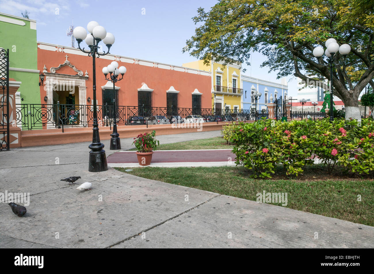 Ripristinato l'architettura coloniale Spagnola con ornati in ferro battuto recinzione attraverso da un centro parco nel centro storico di Campeche, Messico. Foto Stock