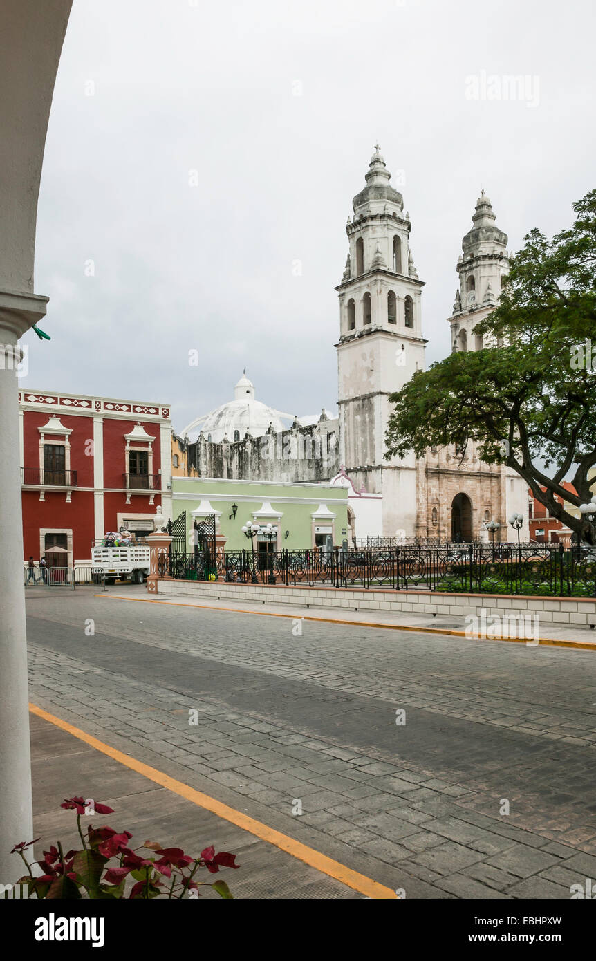 Campeche centro città tra cui la Cattedrale di Campeche, tradizionale colorata architettura coloniale spagnola, visto da sotto un arco sul lato steet, Messico Foto Stock