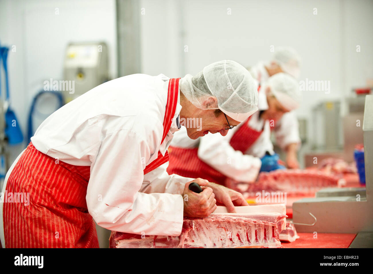 Macellerie al lavoro in una trasformazione della carne factory Foto Stock