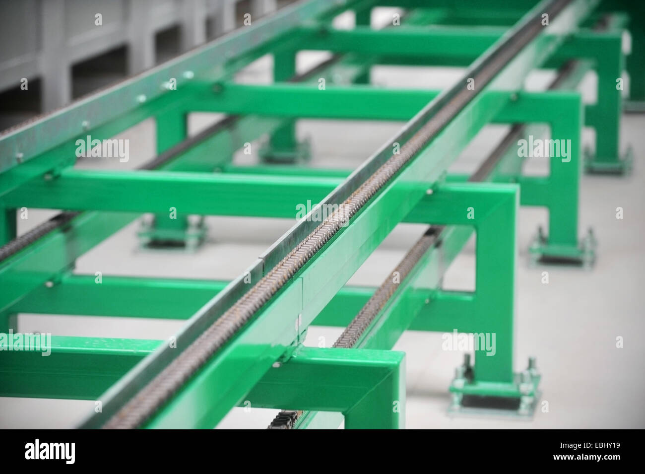 Dettaglio industriale con una fascia verde della catena del convogliatore Foto Stock
