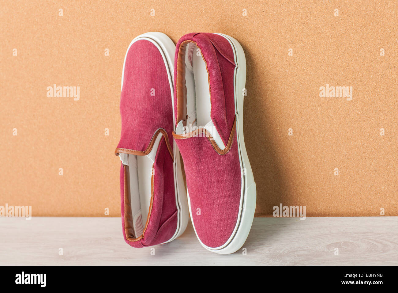 Red Sneaker su uno sfondo di legno, slip-sulle scarpe Foto Stock