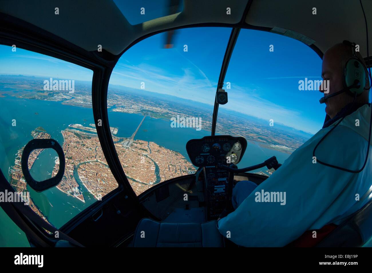 Pilota di elicottero in Robinson R44 su Venezia, Italia e Europa Foto Stock