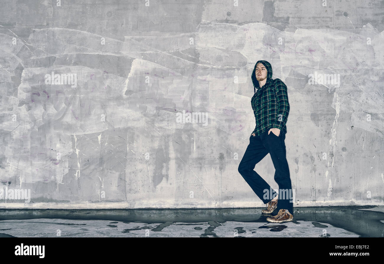 Bel giovane si appoggia contro un muro di cemento, croce immagine elaborata Foto Stock