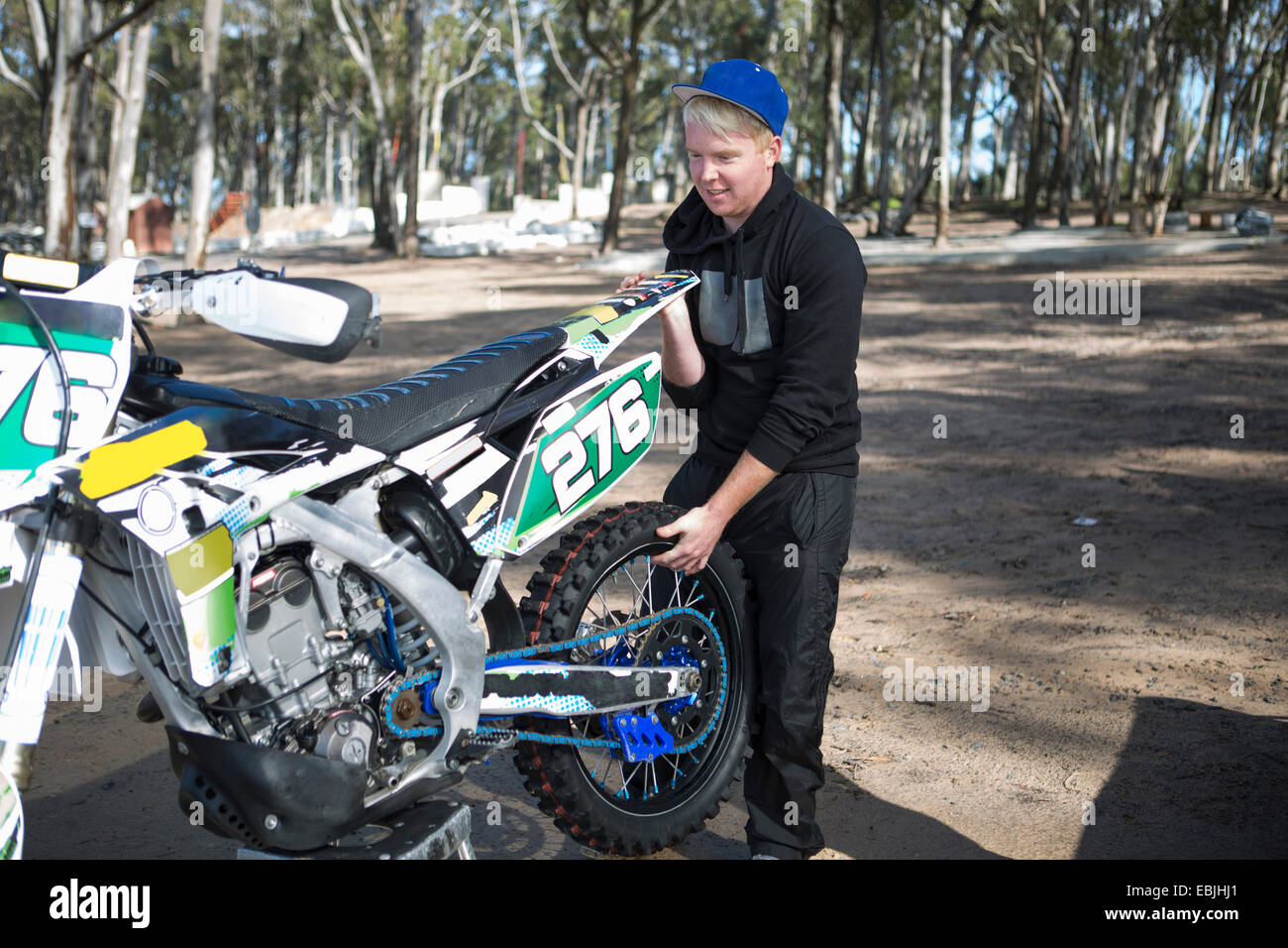 Giovane maschio concorrente di motocross moto di sollevamento nella foresta Foto Stock