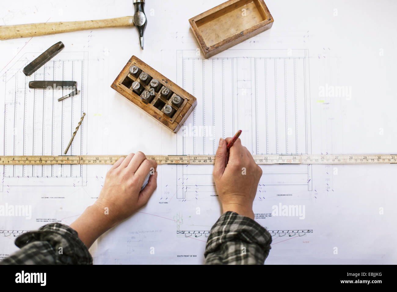 Le mani del giovane craftswoman blueprint di misurazione in organo a canne workshop Foto Stock
