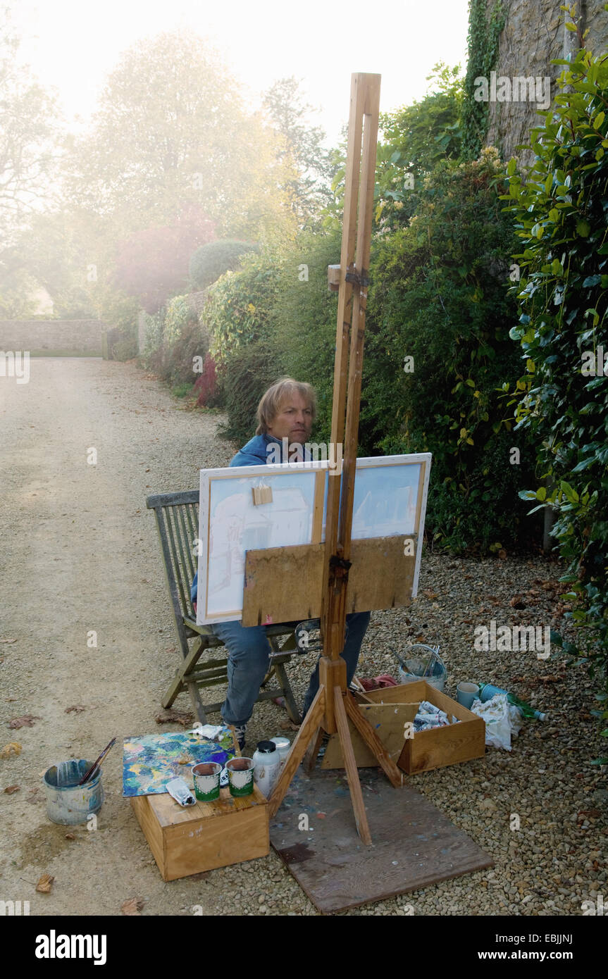 Maschio maturo artista pittura sul viale di casa Foto Stock