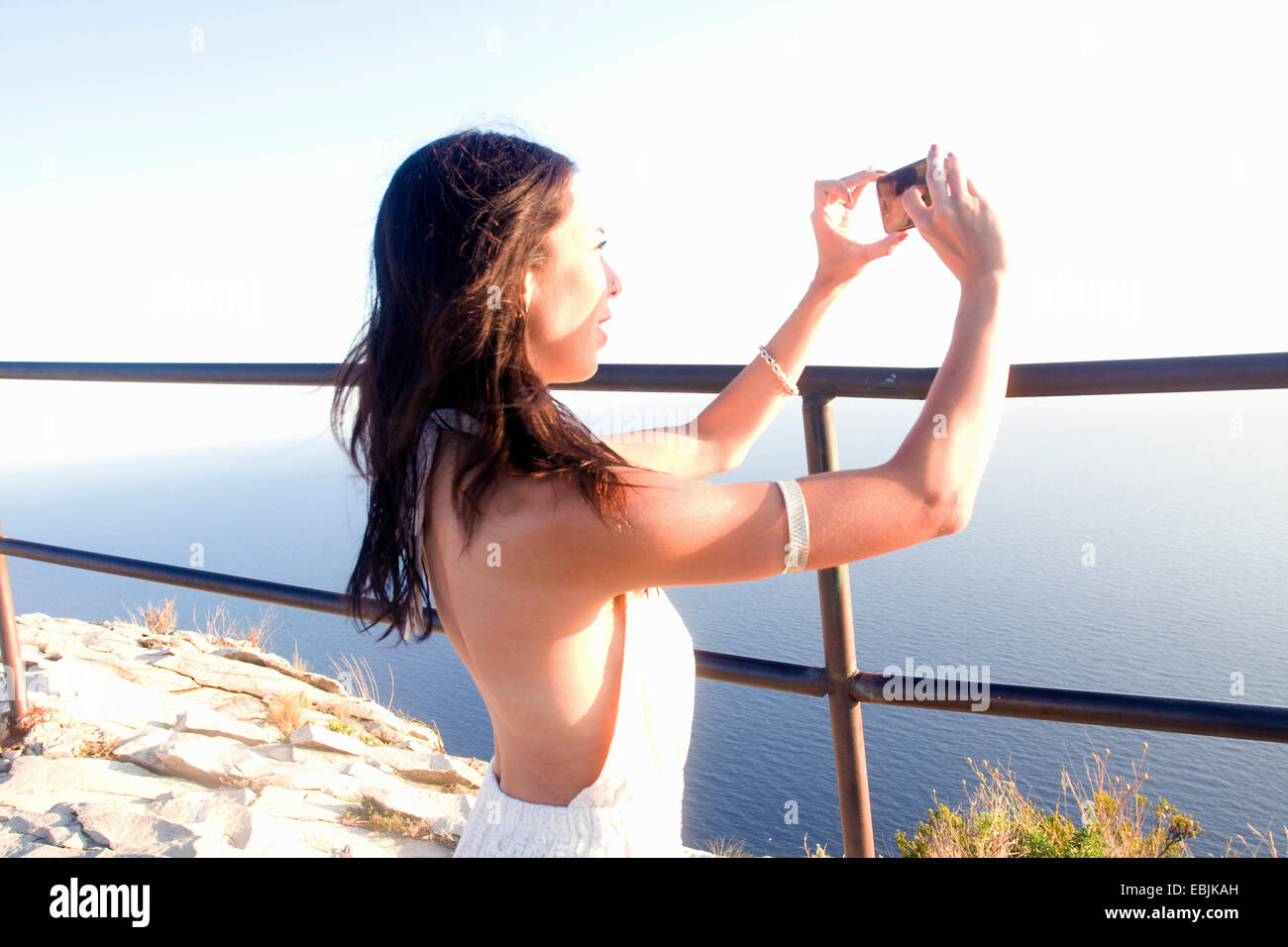 Giovane donna fotografare mare sullo smartphone, Marsiglia, Francia Foto Stock