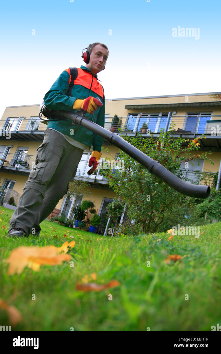 Giardiniere lavora con soffiatori di fogliame, Germania Foto Stock