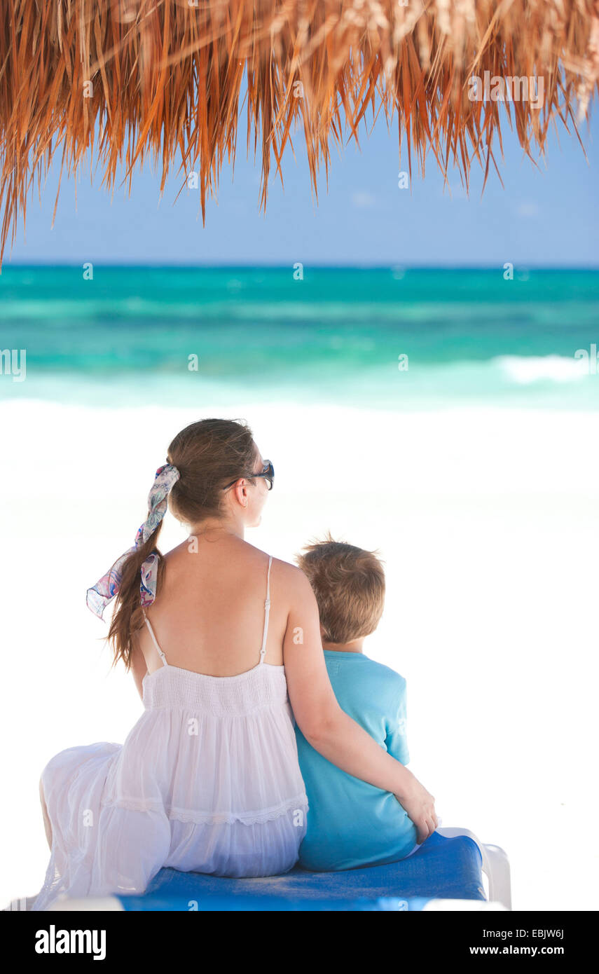 La madre e il Figlio seduto alla spiaggia tropicale, Messico Tulum Foto Stock