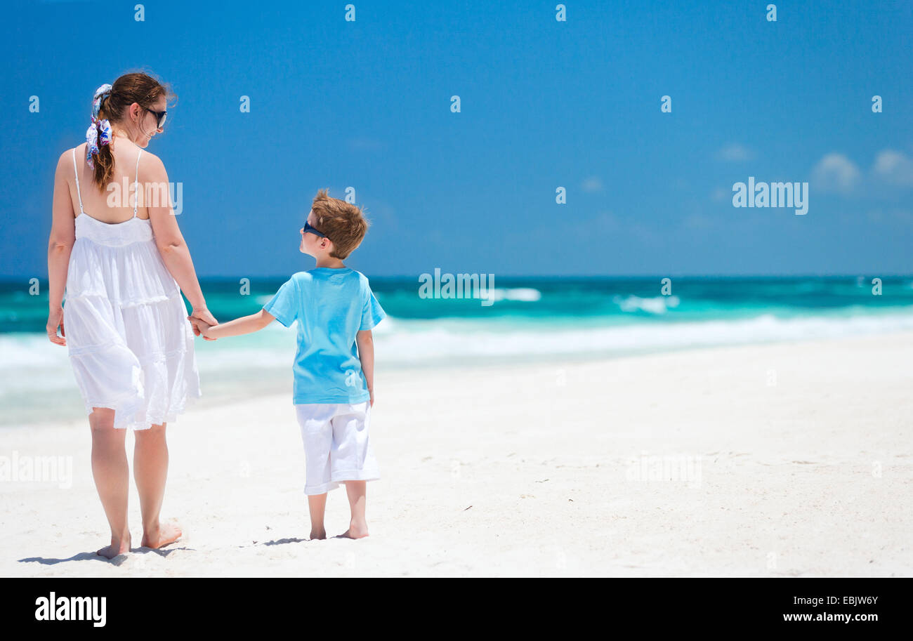 Madre e figlio camminando sulla spiaggia tropicale, Messico Foto Stock
