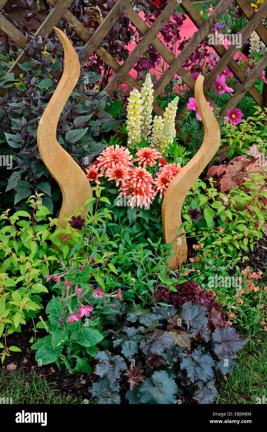 Dettaglio di un giardino decorativo confine con Heuchera, lupini e dalie Foto Stock