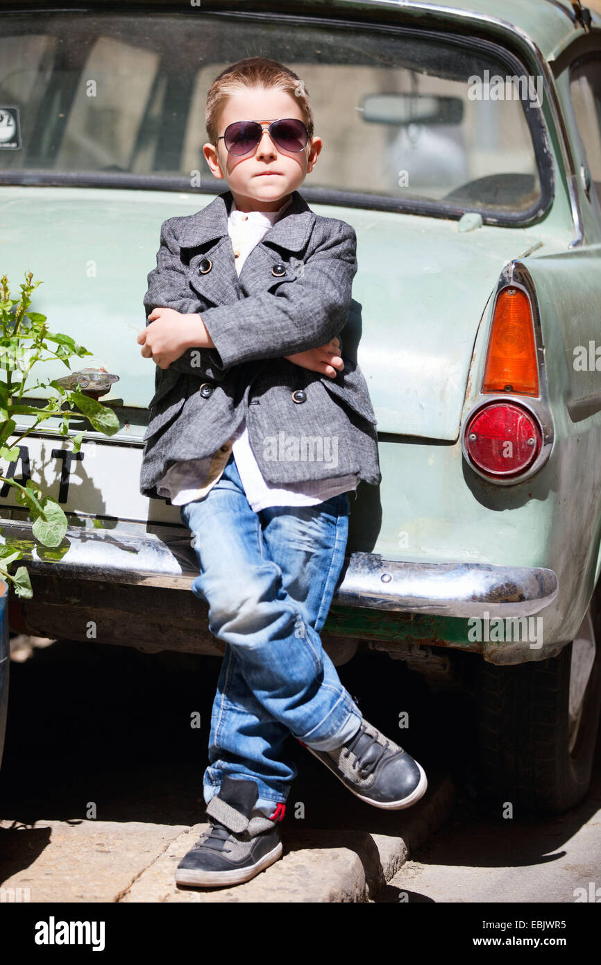 Little Boy sta in piedi in una vecchia auto Foto Stock