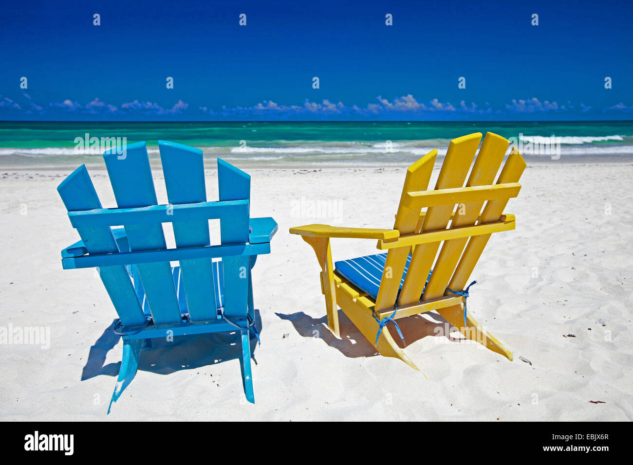 Due colorate sedie in legno permanente sulla spiaggia di sabbia dei Caraibi costa, Messico Foto Stock