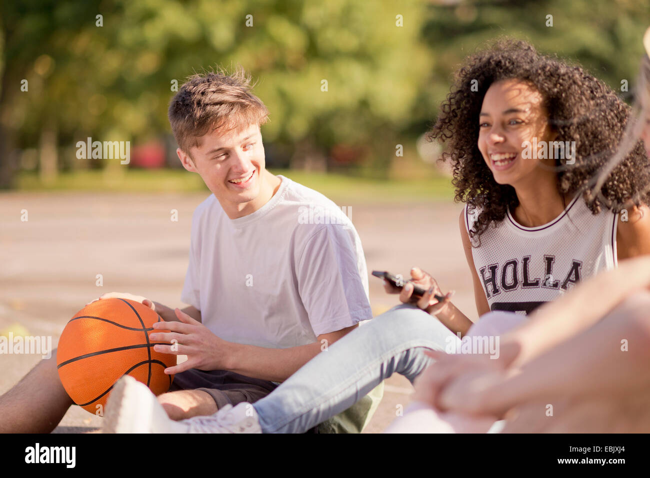 Gruppo di adulti giovani giocatori di basket seduta in chat Foto Stock