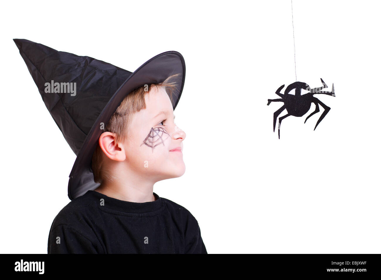 Ragazzo costuming con magic hat guardando il ragno nero Foto Stock