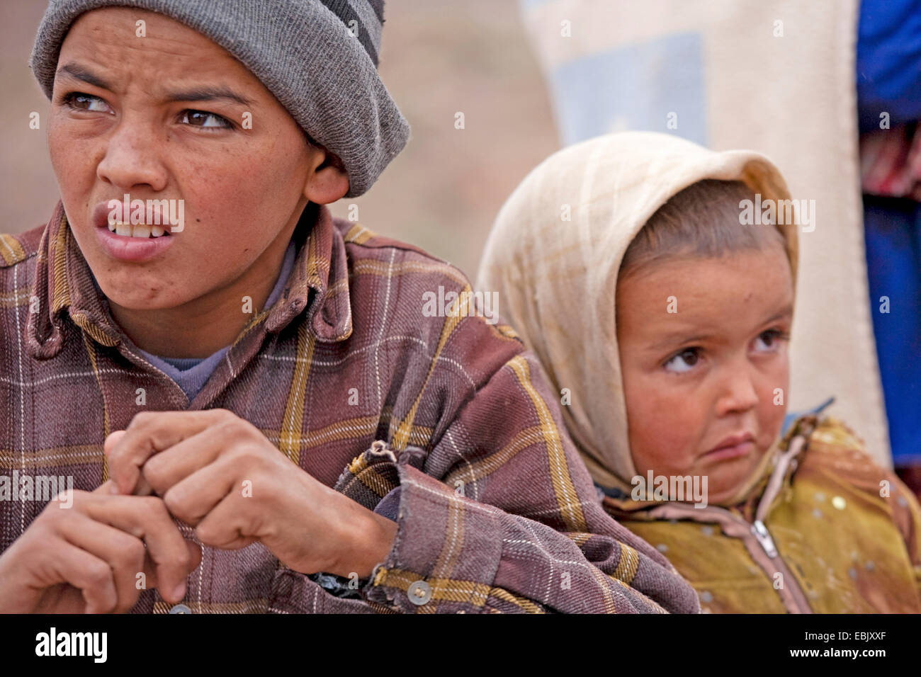 Due fratelli poveri distressed seduta accanto a ciascun altro, Marocco, Souss-Massa-DaraÔ, Djebel Sarhro, Antiatlas Foto Stock