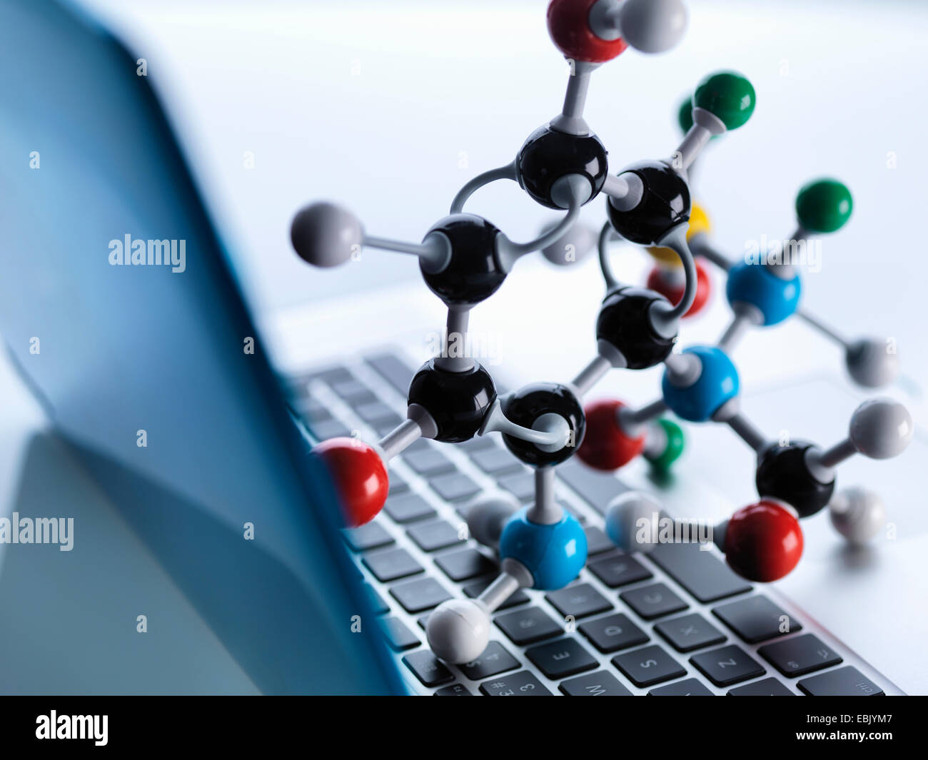 Il modello molecolare seduto sulla parte superiore del computer lap top tastiera per illustrare la scienza dell'educazione e computer aided research Foto Stock
