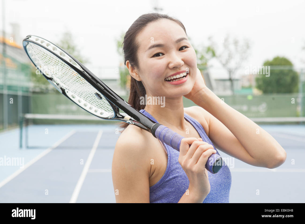 Ritratto di giovane donna giocatore di tennis sul campo da tennis Foto Stock