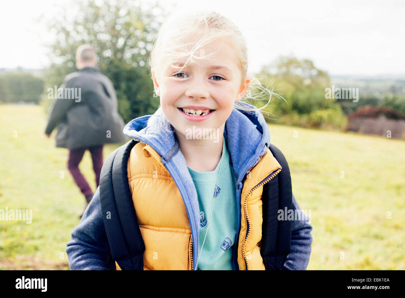 Giovane ragazza gilet da indossare, sorridente Foto Stock