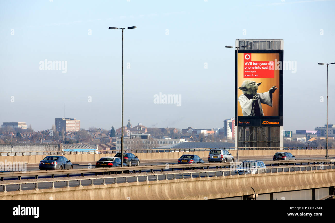 Macchine passano un illuminato pubblicità stradale board accanto all'autostrada M5, Oldbury, Birmingham. Tra i raccordi 3 e 2. Foto Stock