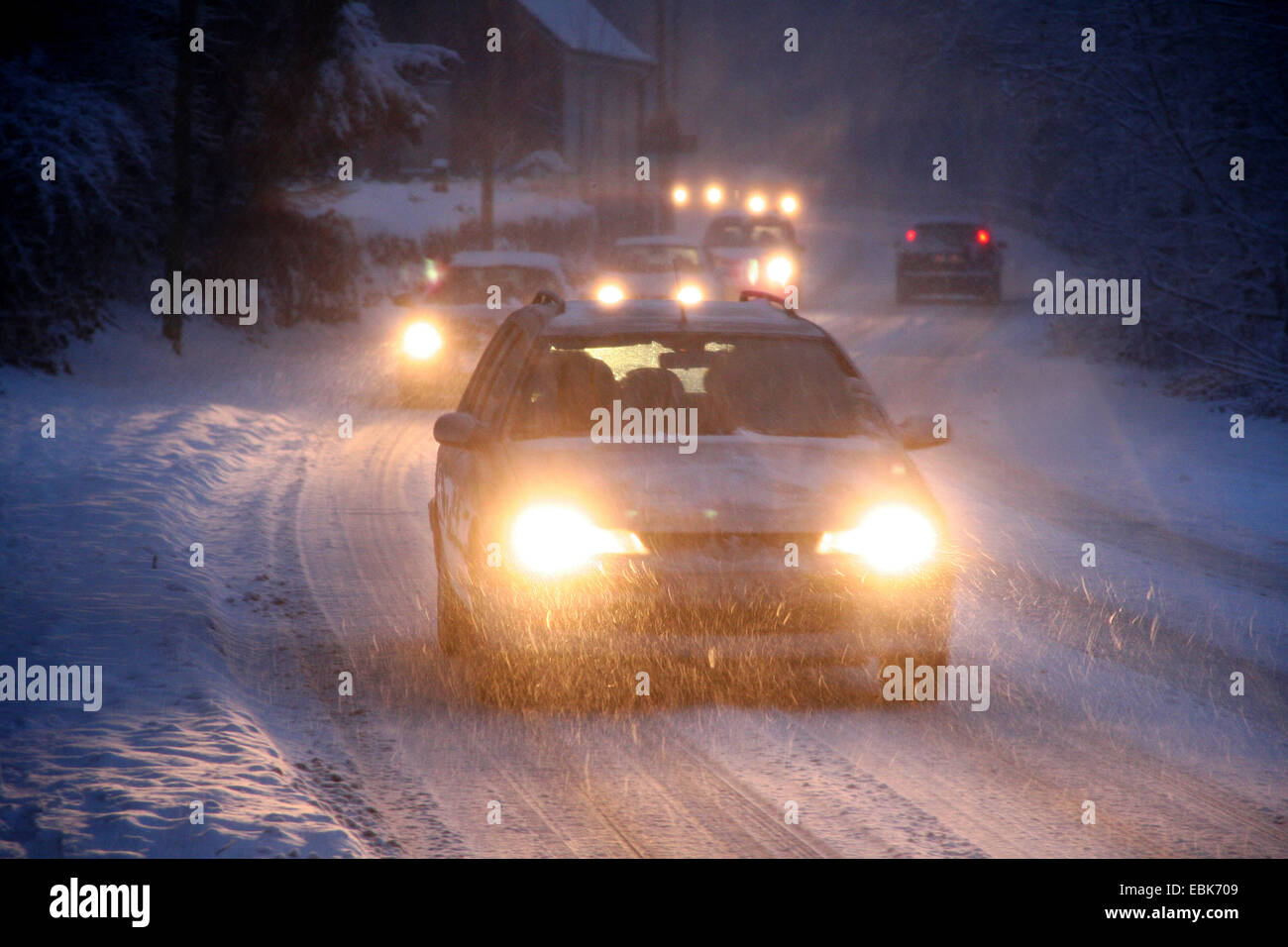 In movimento lento del traffico su una strada innevata di sera, in Germania, in Renania settentrionale-Vestfalia Foto Stock