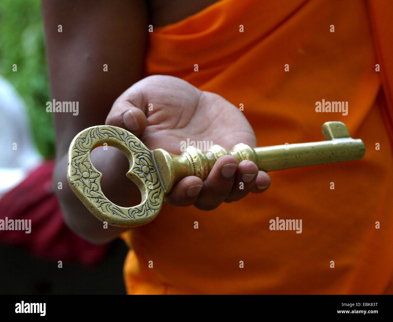 Munk tenendo premuto un tasto d'oro in mano , Sri Lanka, uva, Bandarawela Foto Stock